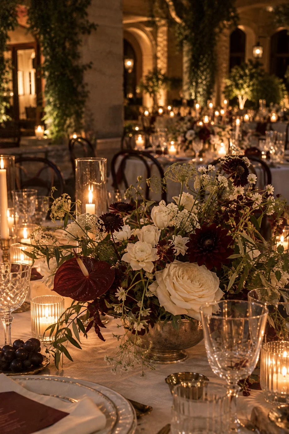 Candlelit centrepiece of white roses and burgundy dahlias